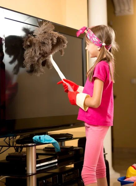 Κορίτσι σε λαστιχένια γάντια καθαρισμού μεγάλη τηλεόραση από τη σκόνη με βούρτσα — Φωτογραφία Αρχείου