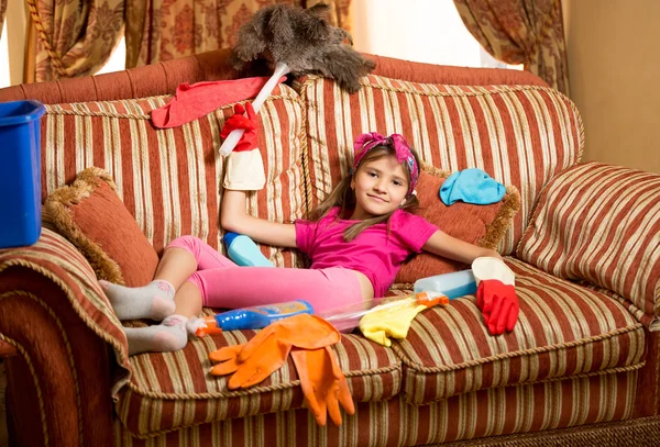 Menina exausta relaxando no sofá após a limpeza da casa — Fotografia de Stock