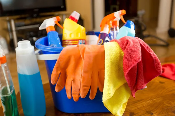 Primo piano di secchio pieno di prodotti per la pulizia in soggiorno — Foto Stock
