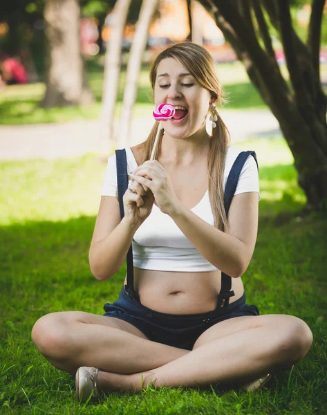 Funny shot of pregnant woman looking at lollipop — Stock Photo, Image