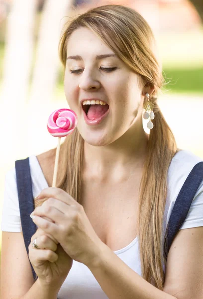 Funny portrait of woman with pigtails looking at lollipop — Stock Photo, Image