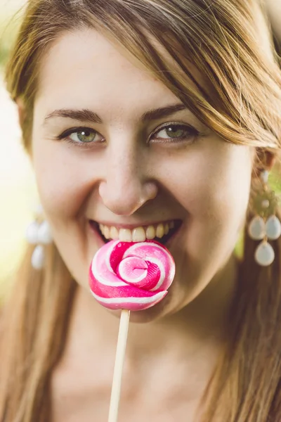 Cute woman licking red twisted lollipop — Stock Photo, Image