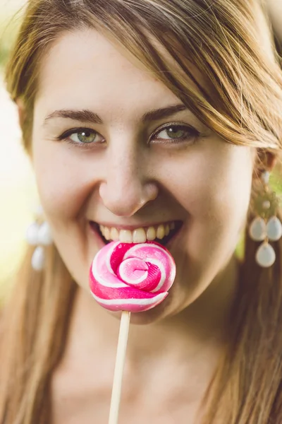 Wanita cantik menjilati lolipop bengkok merah — Stok Foto