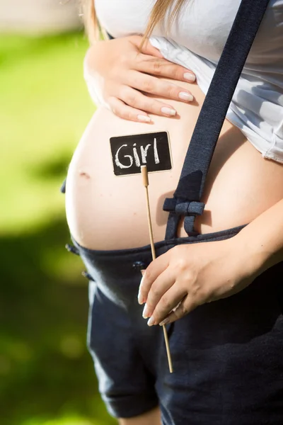 Gravid kvinna med svarta tavlan på buken med ordet "Girl" — Stockfoto