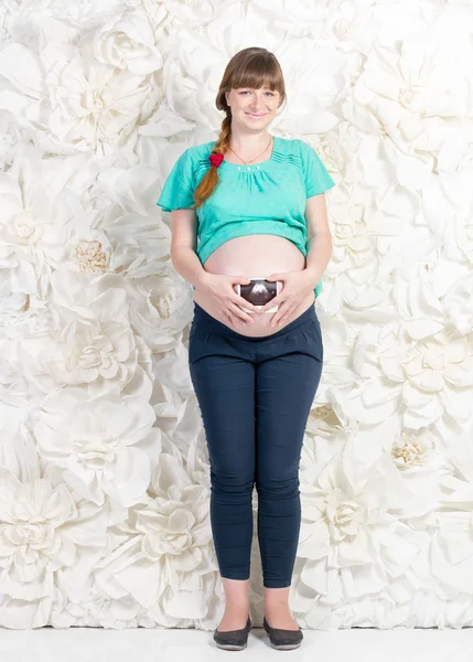 Pregnant woman posing with ultrasonic baby image — Stock Photo, Image