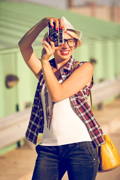 gülümseyen şık kız sokakta retro film kamera ile poz