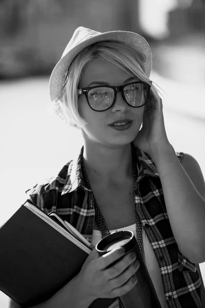 Stylish woman in eyeglasses and hat posing on street at sunny da — Stock Photo, Image