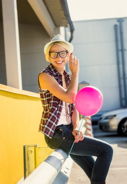 Portrait of stylish girl in eyeglasses and hat posing with ballo — Stock Photo, Image