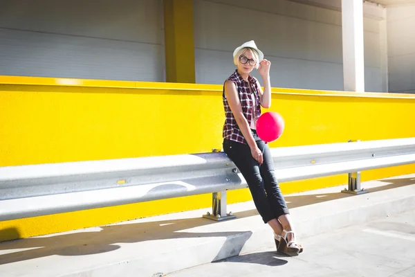 Hipster girl with red balloon posing at parking lot — Stock Photo, Image