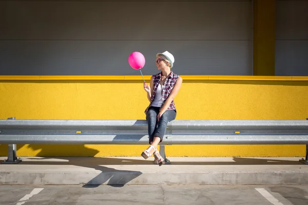 Toned photo of stylish hipster girl posing with pink balloon — Stock Photo, Image
