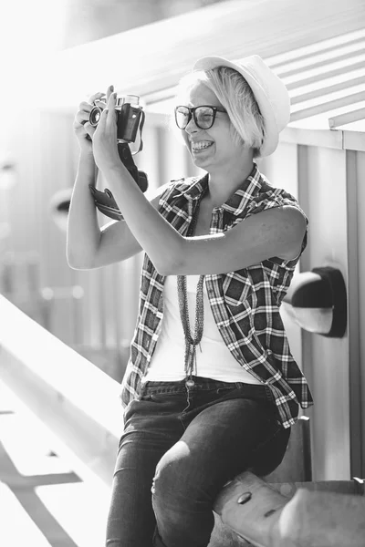 Портрет улыбающейся хипстерши, делающей фото с винтажной камерой — стоковое фото