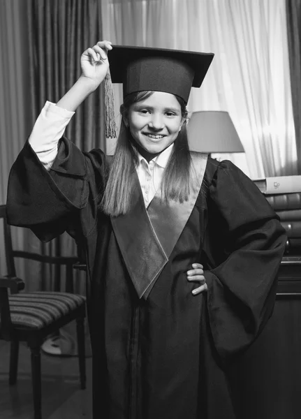 Black and white portrait of little girl holding graduation cap — Stock Photo, Image