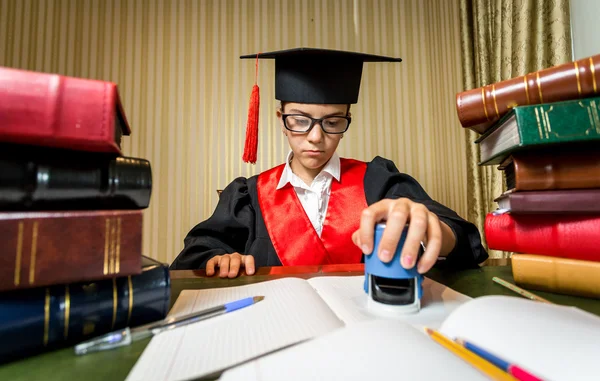 Chica en la graduación gorra jugando en abogado y poniendo sello en do —  Fotos de Stock