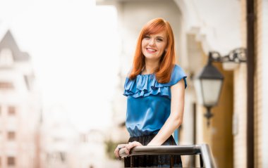 Kızıl saçlı kadın sokağa poz gülüyor