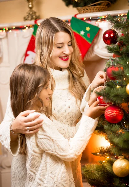 Gelukkig moeder en dochter versieren kerstboom in house — Stockfoto