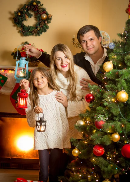 Porträt einer lächelnden Familie, die an Weihnachten mit Laternen posiert — Stockfoto