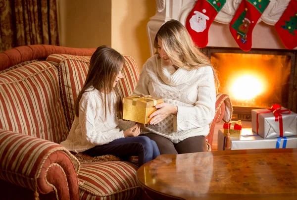 Mutter und Tochter packen Weihnachtsgeschenk am Kamin aus — Stockfoto