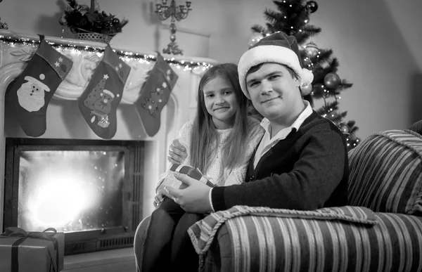 Glückliche Mann und Mädchen sitzen an Weihnachten am Kamin — Stockfoto