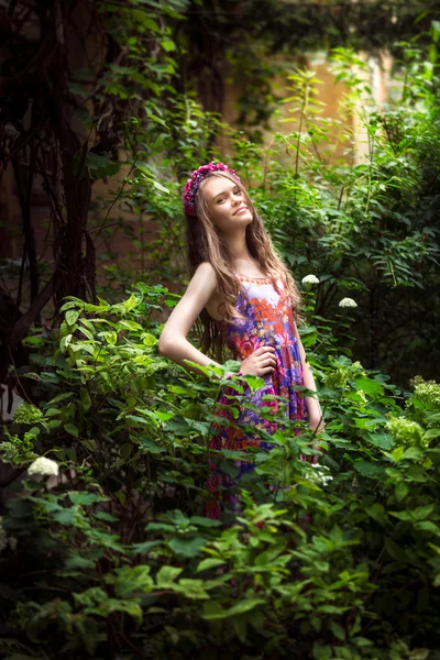 Portret van mooie jonge vrouw die zich voordeed op tuin — Stockfoto