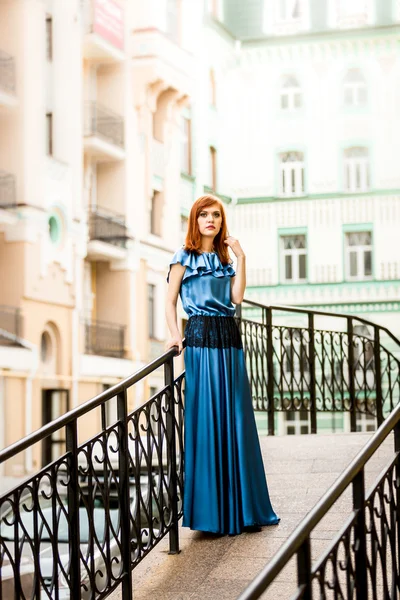 Elegancka kobieta w długiej sukni pozowanie na ulicy na starym mieście — Zdjęcie stockowe