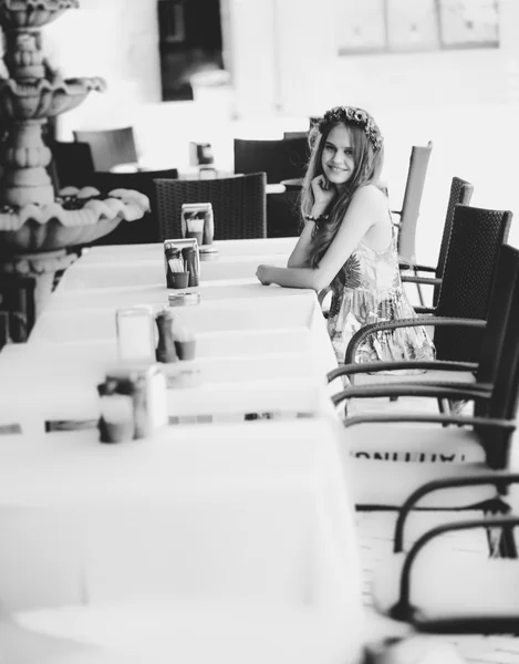 Монохромное фото милой женщины, сидящей за столом в кафе — стоковое фото
