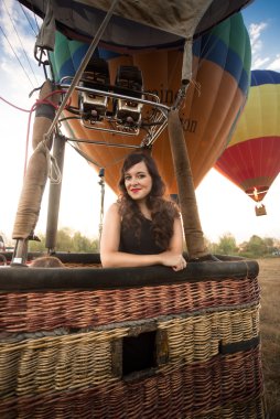 Portrait of beautiful woman posing at hot air balloon basket clipart