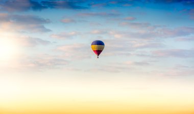 güneş doğarken gökyüzünde yüzen renkli sıcak hava balonu