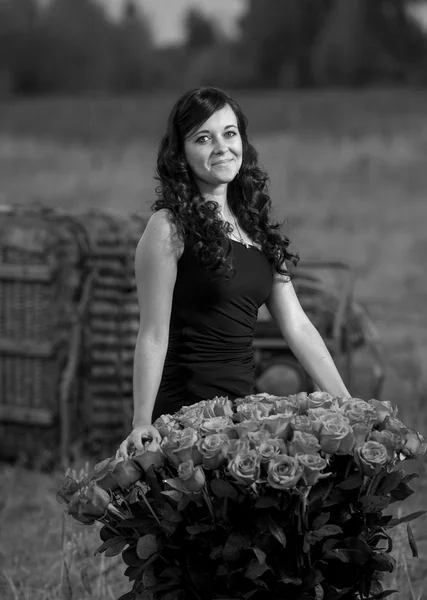 Portret eleganckie kobiety uśmiechający się z róż na łące — Zdjęcie stockowe