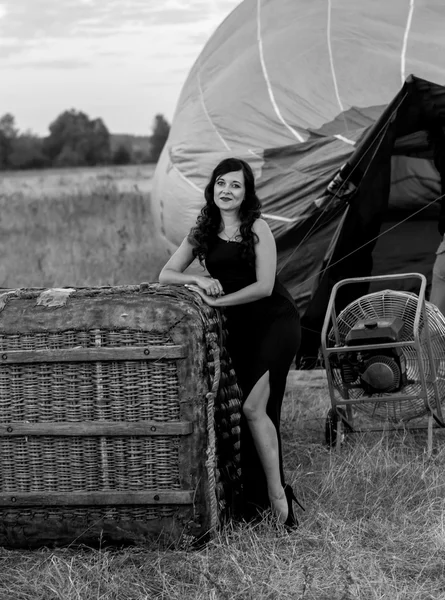 Black and white photo of woman standing at the hot air balloon — Stock Photo, Image
