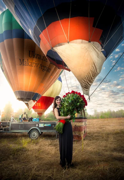 Žena pózuje s růží u horkovzdušný balón — Stock fotografie