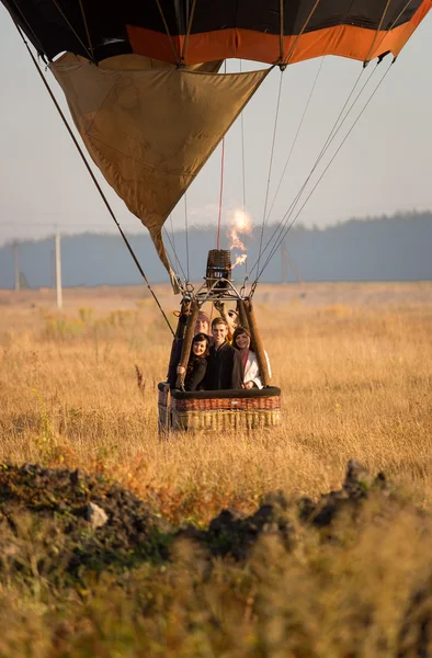 Start des Heißluftballons mit Besatzung auf dem Feld bei Sonnenaufgang — Stockfoto