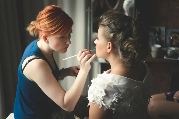 Toned portrait of makeup artist preparing bride at morning — Stock Photo, Image