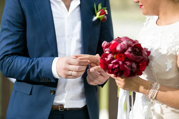 Close-up de noivo jovem colocando anel de casamento no dedo da noiva — Fotografia de Stock