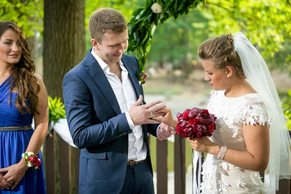 Boldog mosolygó menyasszony és a vőlegény Aranybol gyűrűk felhúzása — Stock Fotó