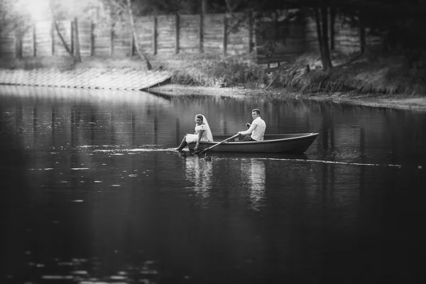 Black and white photo bride and groom riding on boat on lake — Stock Photo, Image