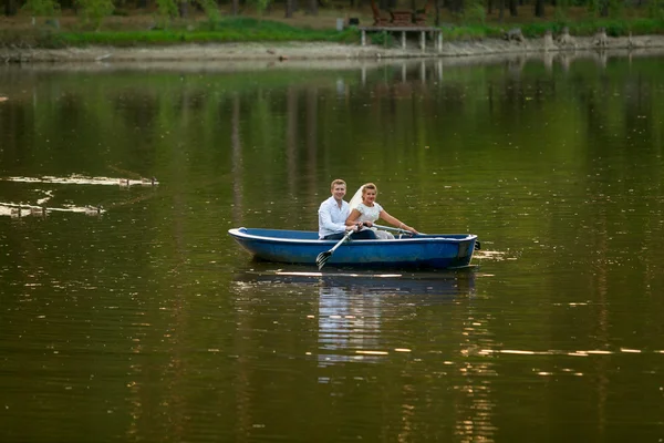 Young bride and groom riding on the boat on lake — Stock Photo, Image