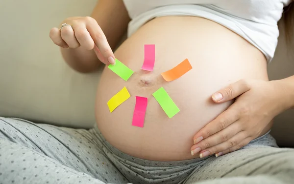 Begreppet gravid kvinna gör val på färgglada klistermärken — Stockfoto