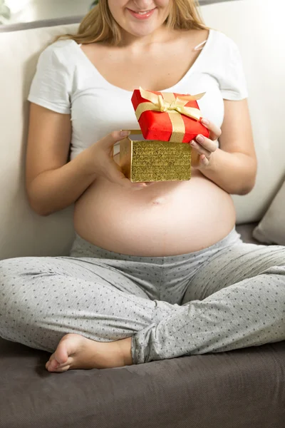 Pregnant woman looking inside of gift box — Stock Photo, Image