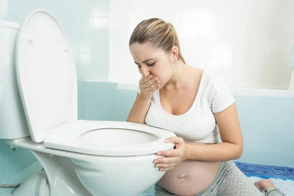 Mujer embarazada sintiéndose enferma en el baño —  Fotos de Stock
