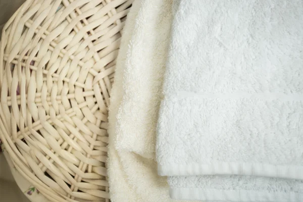 Closeup of white bath towels lying on wicker basket — Stock Photo, Image