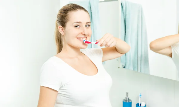 Hermosa mujer morena posando con cepillo de dientes en el baño —  Fotos de Stock