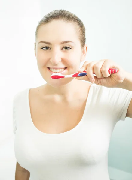 Retrato de bela mulher morena escovando dentes — Fotografia de Stock