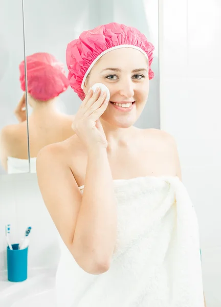 Beautiful smiling woman using face cream after having shower — Stockfoto