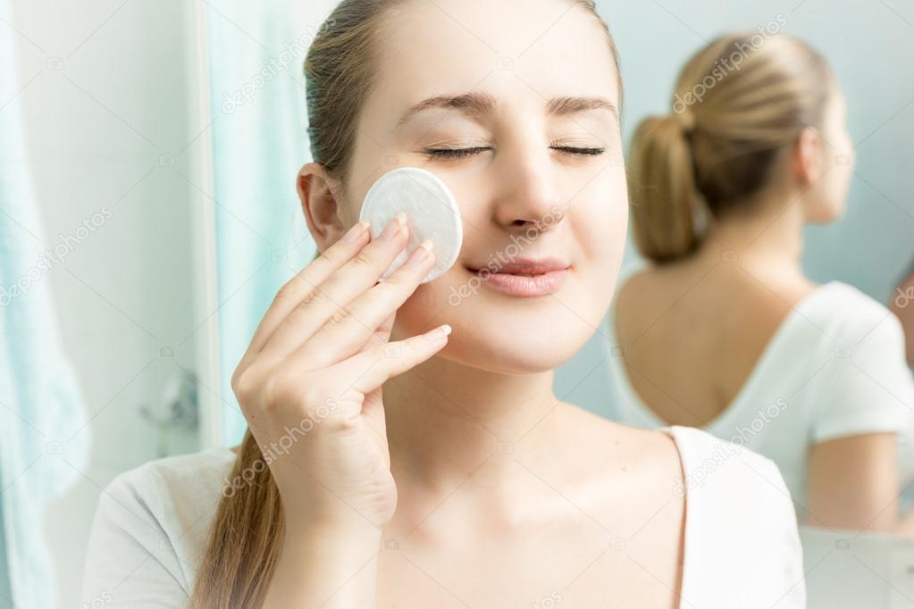 Closeup portrait of beautiful woman cleaning skin
