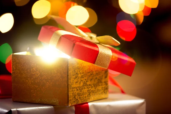 Fechar a caixa de presente de Natal aberta em luzes brilhantes fundo — Fotografia de Stock