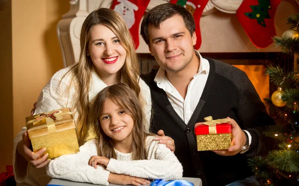 Spokojený úsměv, rodinné pózuje na krb na Vánoce — Stock fotografie