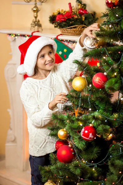 Feliz chica sonriente decorando árbol de Navidad —  Fotos de Stock