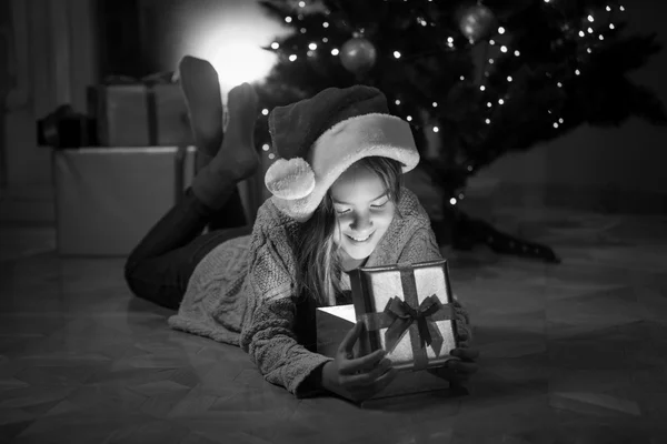 Šťastná holčička ležela s box dárek pod vánoční stromeček — Stock fotografie