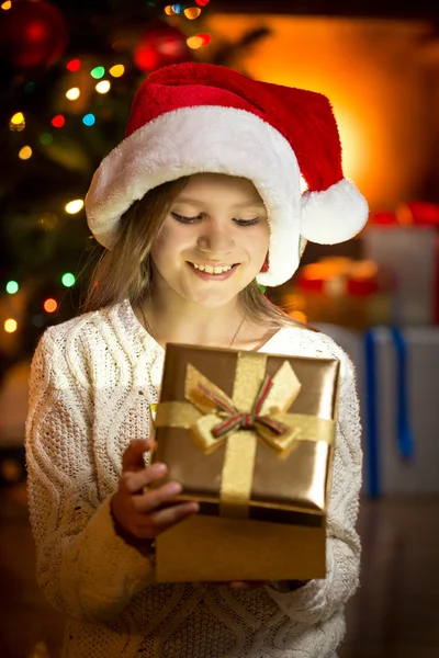 Збуджена дівчина дивиться всередину блискучої подарункової коробки — стокове фото