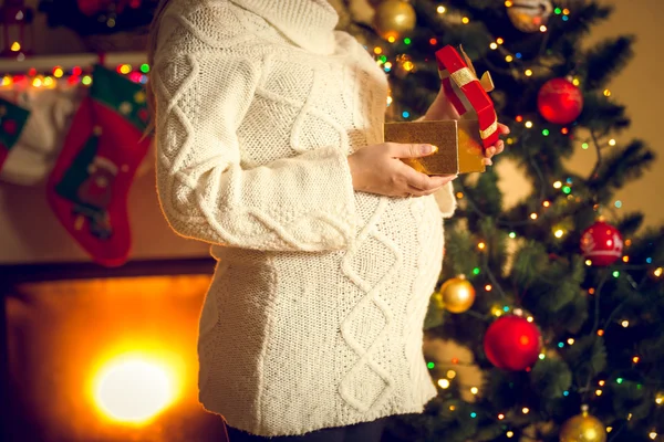 Toned shot of pregnant woman posing with Christmas gift box — Stock Photo, Image